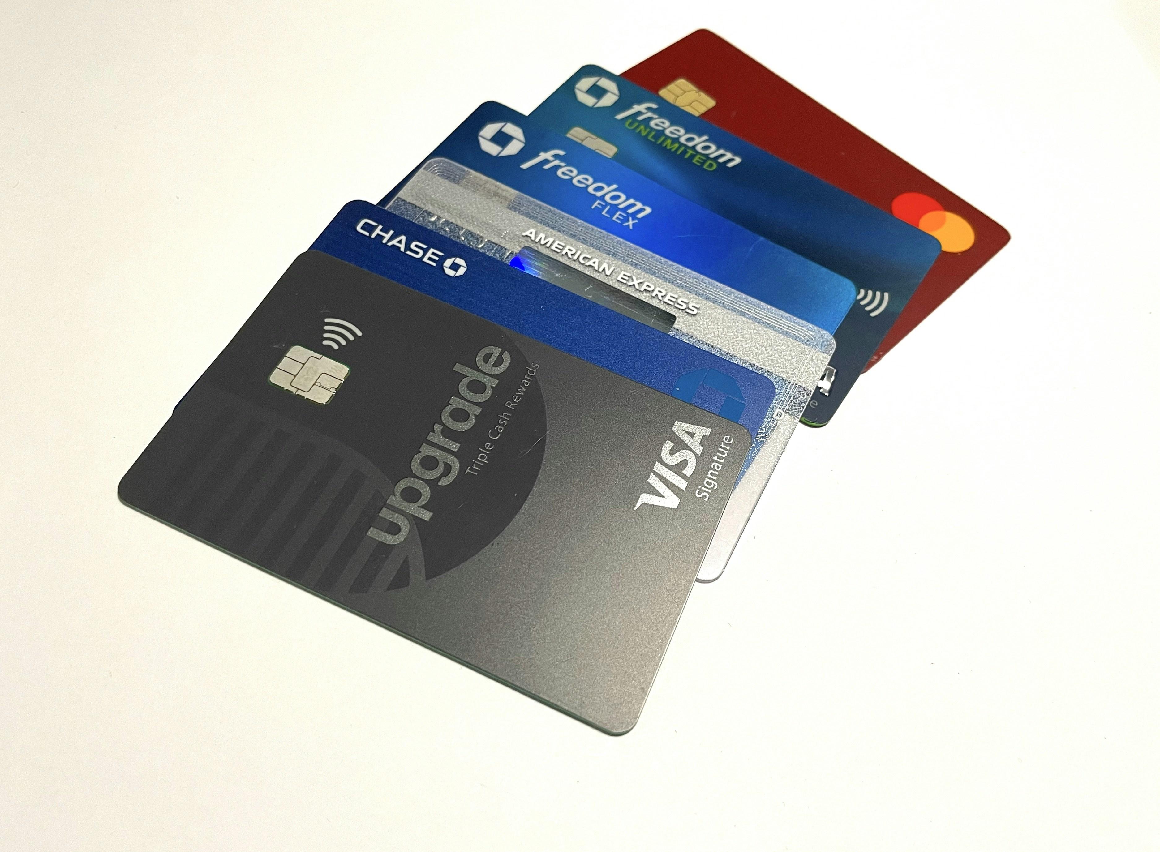 Multiple credit cards fanned out on dark marble surface