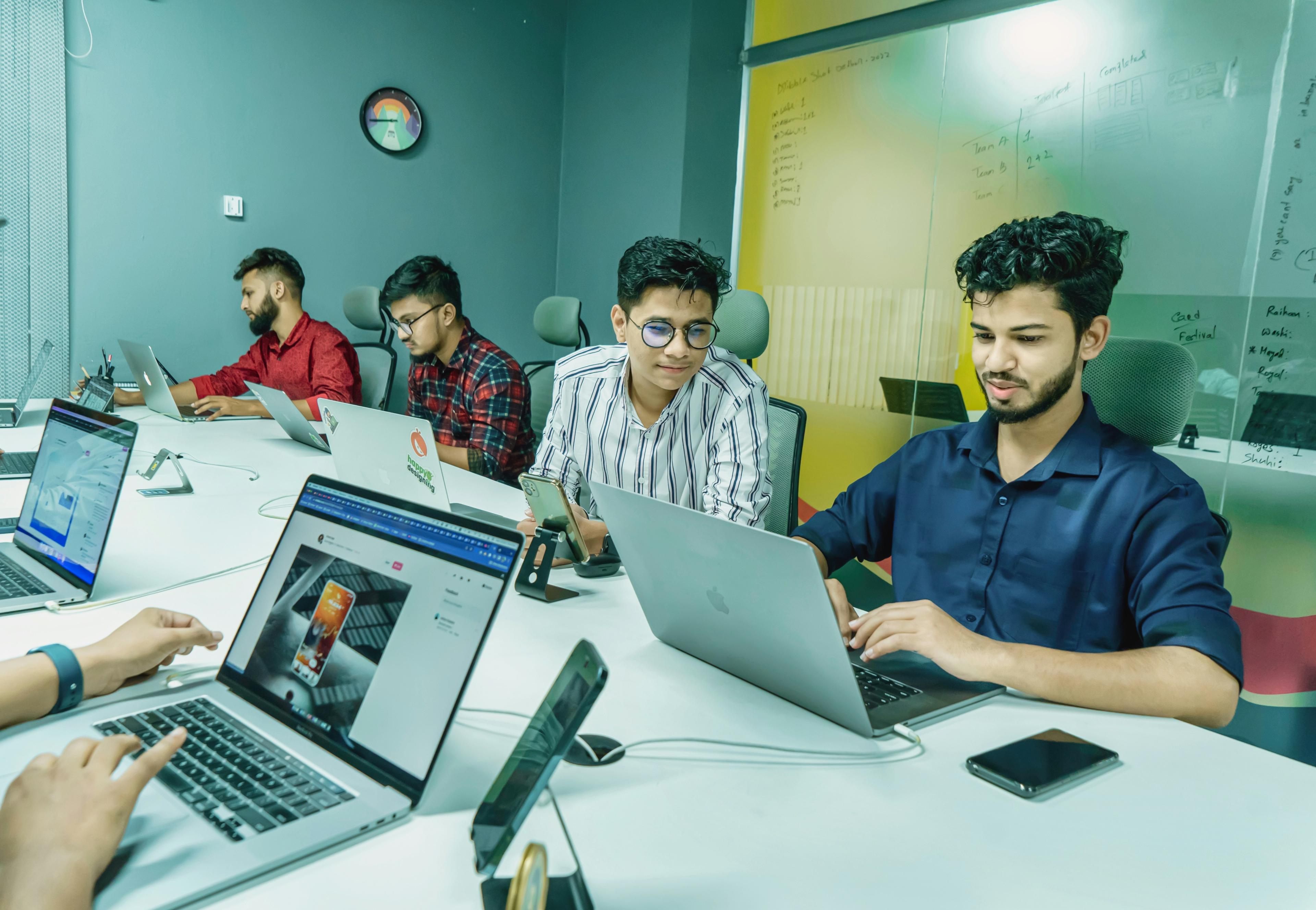 Young professionals collaborating around laptop in modern office environment